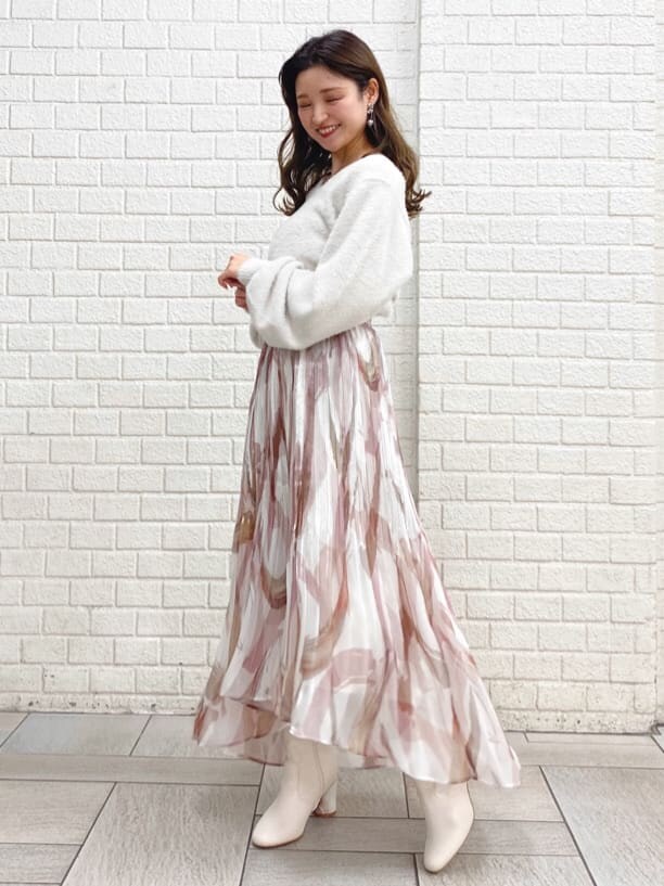 ピンク系のスカート、ホワイト系のニット/セーターを着用したレディースの秋コーディネートの2枚目の写真