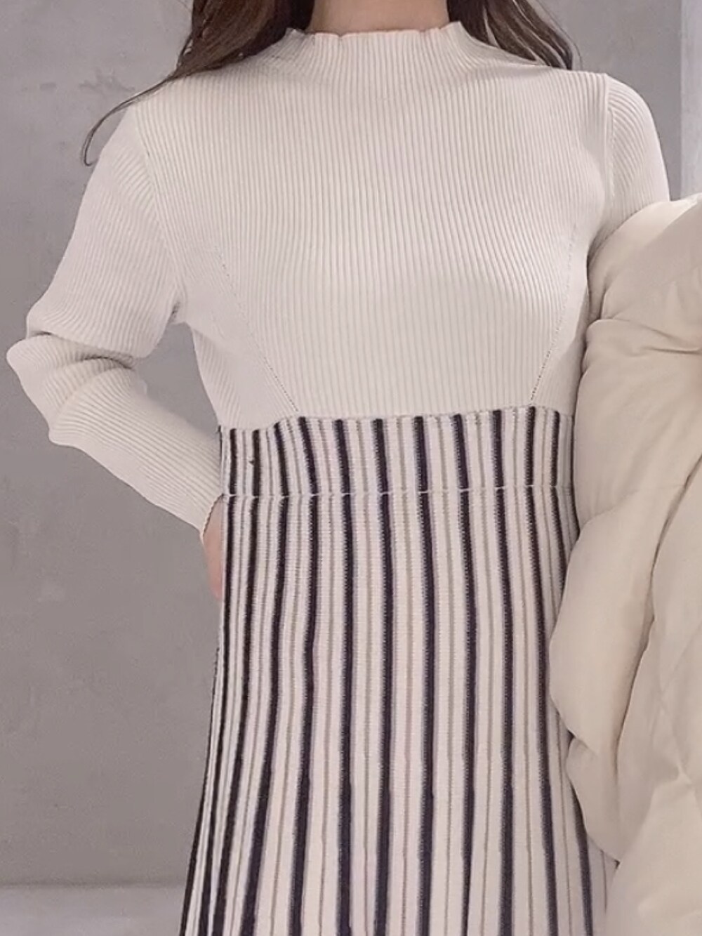 ホワイト系のワンピース、ホワイト系のブーツ、ブラウン系のハンドバッグを着用したレディースの冬コーディネートの8枚目の写真