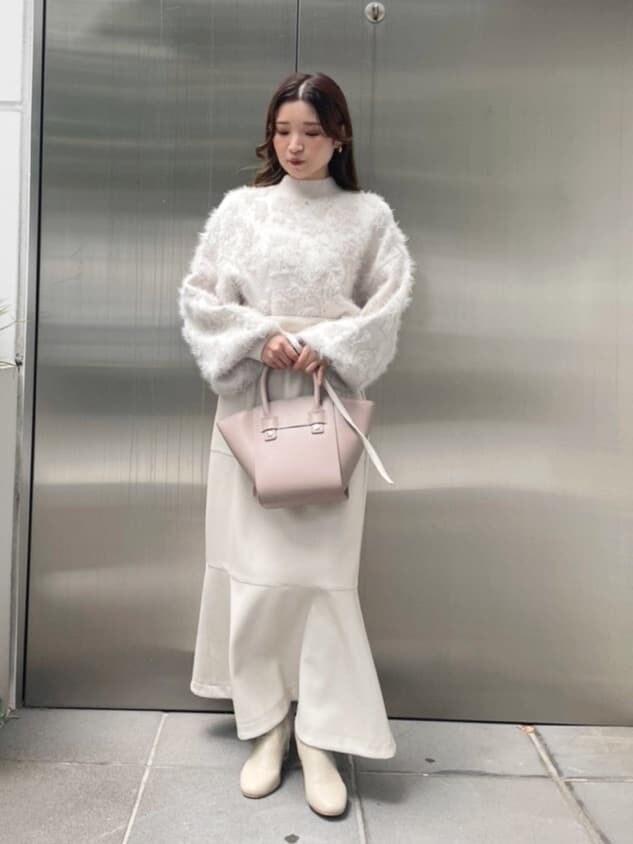 ベージュ系のハンドバッグ、ホワイト系のスカート、ホワイト系のニット/セーターを着用したレディースの秋コーディネートの4枚目の写真