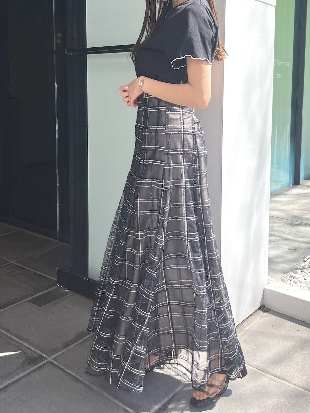 ブラック系のサンダル、ブラック系のスカート、ブラック系のTシャツ/カットソーを着用したレディースの春コーディネートの4枚目の写真