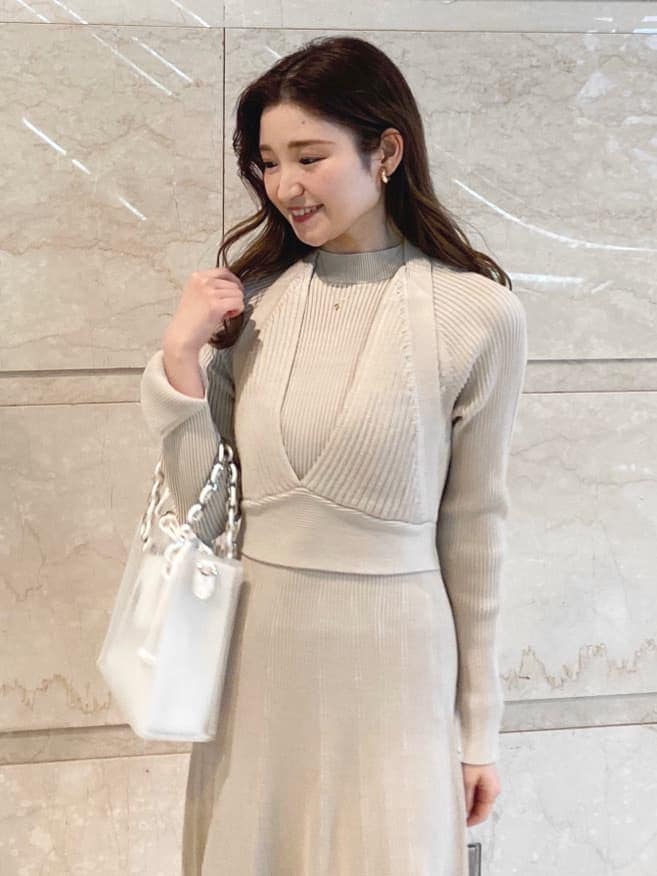 ベージュ系のワンピース、ホワイト系のハンドバッグを着用したレディースの冬コーディネートの4枚目の写真
