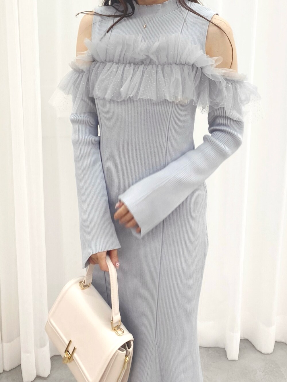 ホワイト系のブーツ、ブルー系のワンピース、ホワイト系のハンドバッグを着用したレディースの秋コーディネートの5枚目の写真