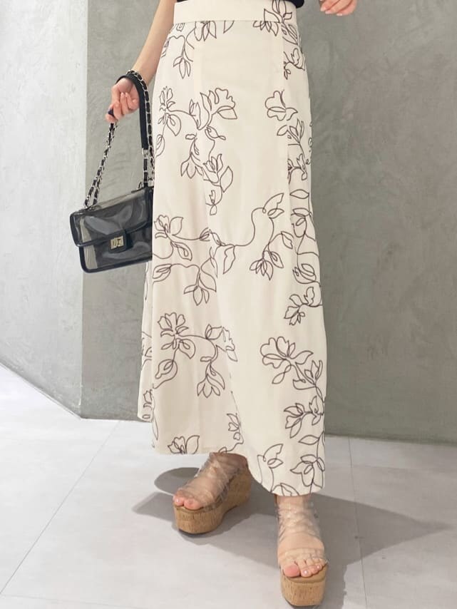 ブラック系のショルダーバッグ、ブラック系のニット/セーター、ホワイト系のスカートを着用したレディースの夏コーディネートの9枚目の写真