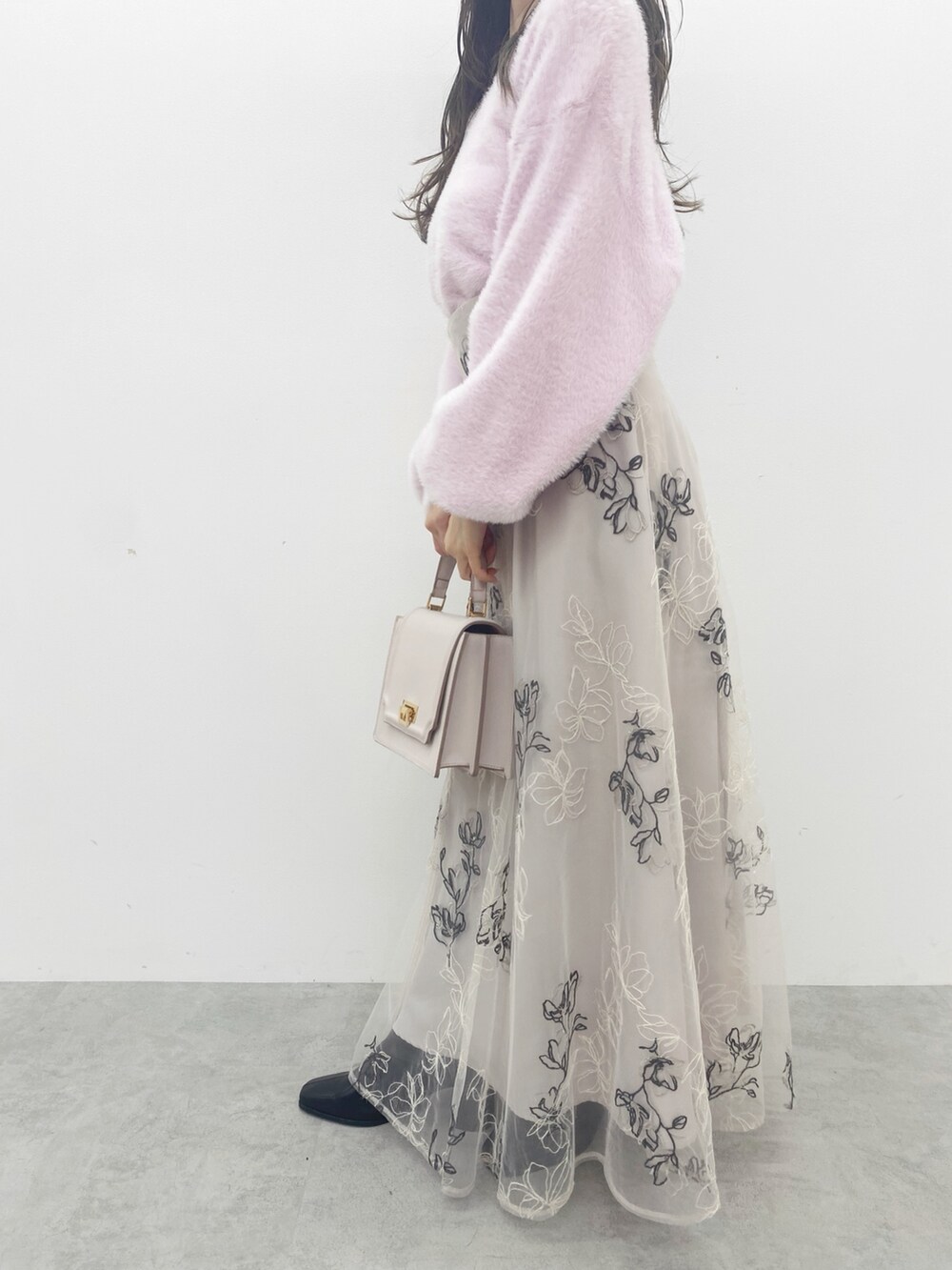 ピンク系のハンドバッグ、ブラック系のブーツ、ピンク系のニット/セーターを着用したレディースの秋コーディネートの5枚目の写真