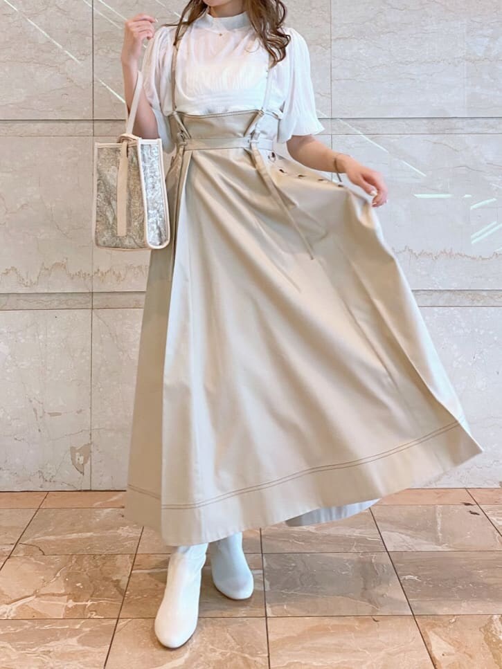 ベージュ系のハンドバッグ、ホワイト系のニット/セーター、ベージュ系のスカートを着用したレディースの夏コーディネートの3枚目の写真