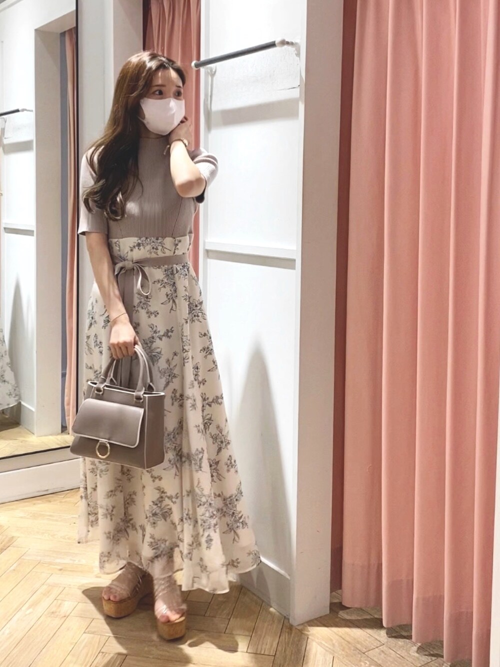 ホワイト系のサンダル、ベージュ系のハンドバッグ、ホワイト系のワンピースを着用したレディースの冬コーディネートの2枚目の写真