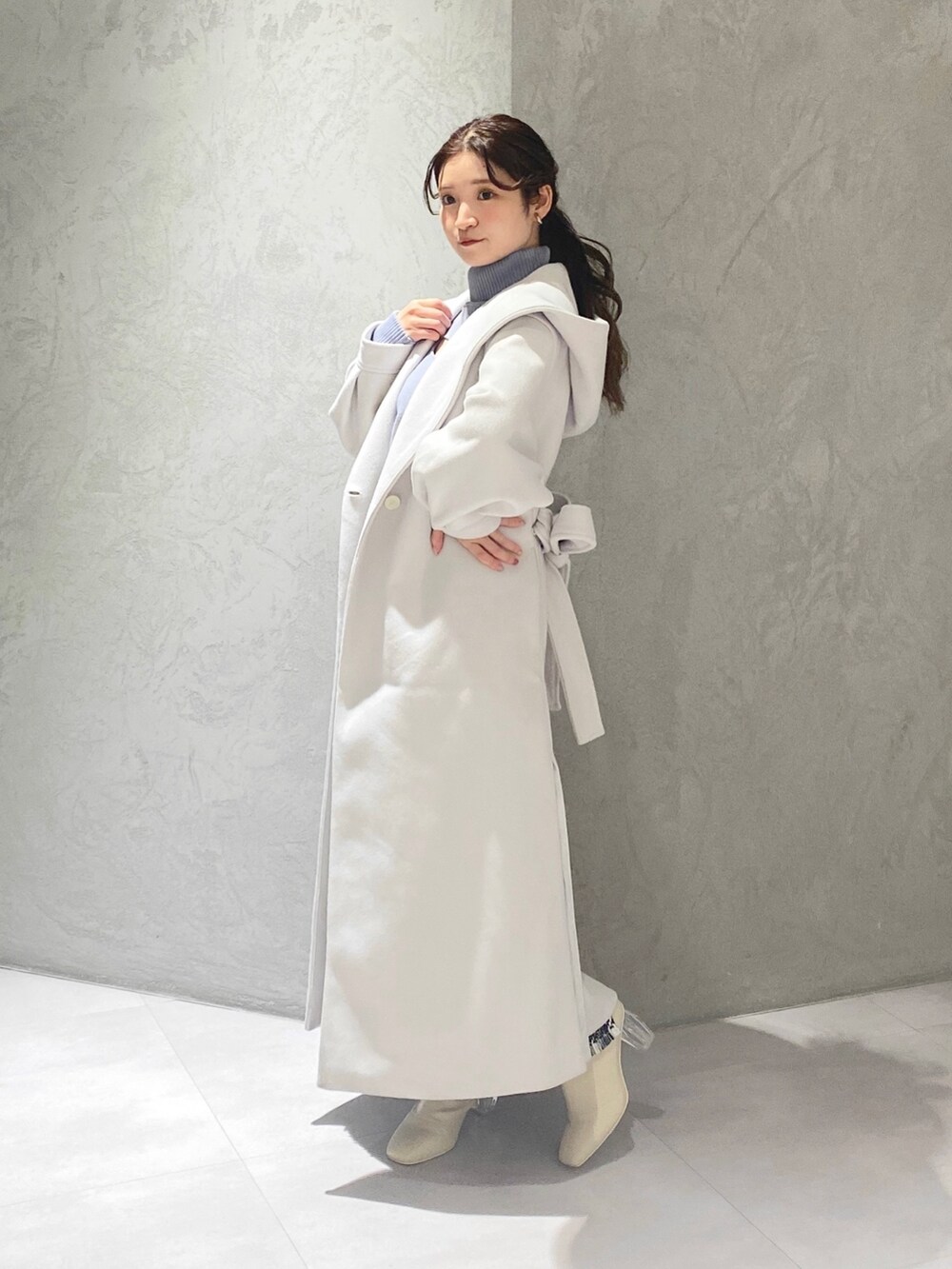 ホワイト系のスカート、ブルー系のニット/セーター、ホワイト系のチェスターコートを着用したレディースの冬コーディネートの6枚目の写真