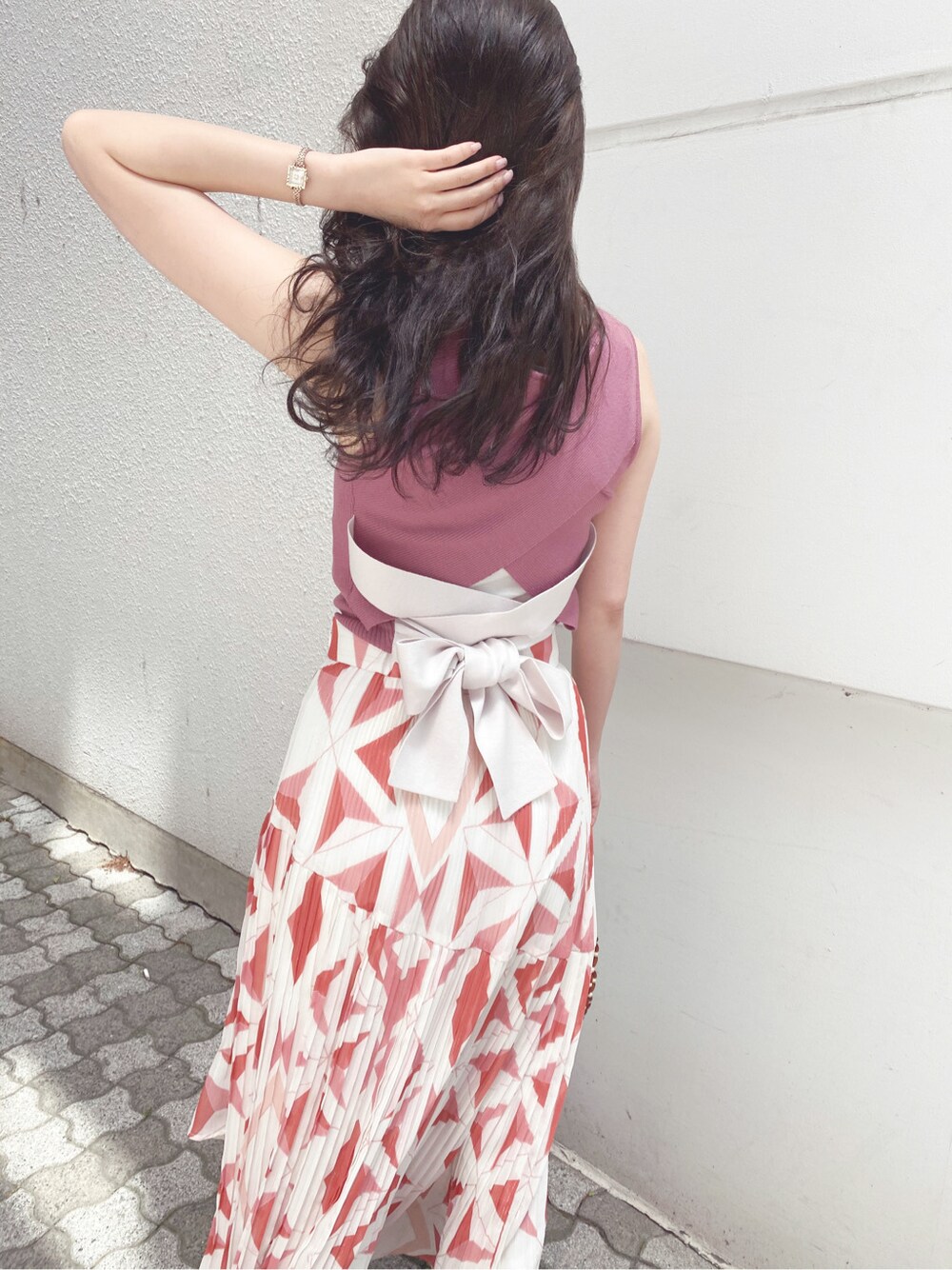 ホワイト系のサンダル、オレンジ系のスカート、ブラウン系のハンドバッグを着用したレディースの春コーディネートの2枚目の写真