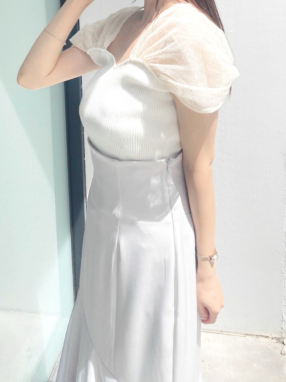 グレー系のスカート、ホワイト系のサンダル、ホワイト系のニット/セーターを着用したレディースの夏コーディネートの4枚目の写真