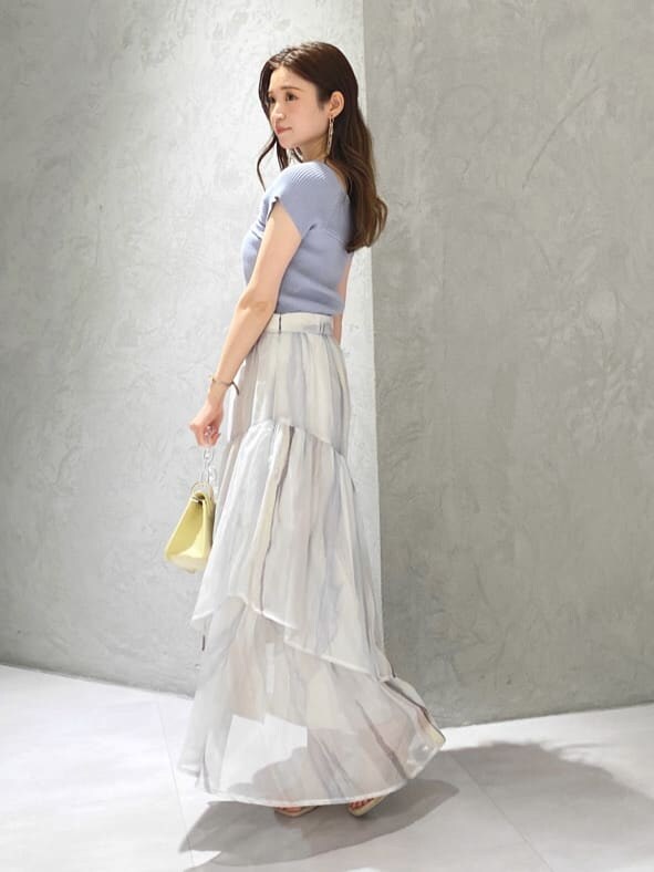 ピンク系のスカート、ブルー系のニット/セーター、ベージュ系のサンダルを着用したレディースの春コーディネートの3枚目の写真