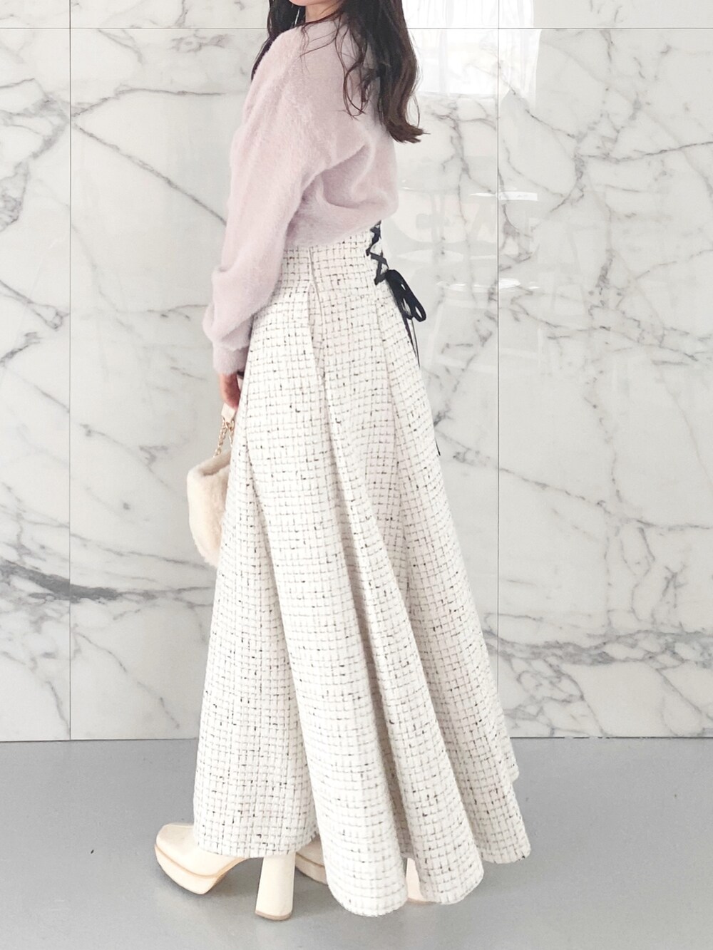 ホワイト系のブーツ、ホワイト系のハンドバッグ、ホワイト系のスカートを着用したレディースの秋コーディネートの3枚目の写真