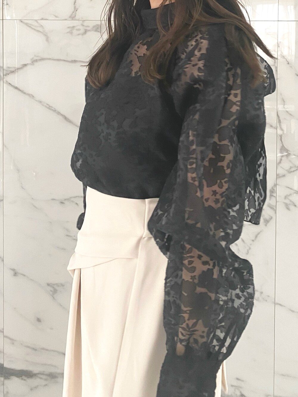 ブラック系のシャツ/ブラウス、ホワイト系のスカート、ブラック系のブーツを着用したレディースの冬コーディネートの4枚目の写真