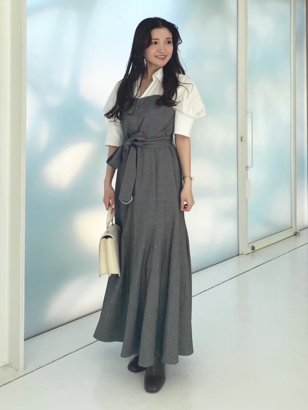 ホワイト系のハンドバッグ、その他のワンピース、ブラウン系のブーツを着用したレディースの秋コーディネートの6枚目の写真