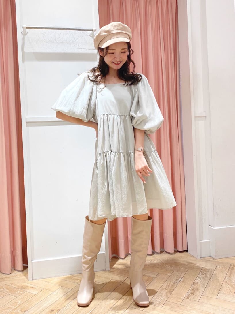 グリーン系のワンピース、ベージュ系のブーツ、ベージュ系のキャスケットを着用したレディースの秋コーディネートの9枚目の写真