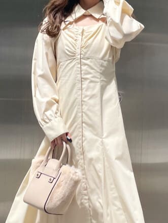 ベージュ系のブーツ、ホワイト系のハンドバッグ、ホワイト系のワンピースを着用したレディースの秋コーディネートの4枚目の写真