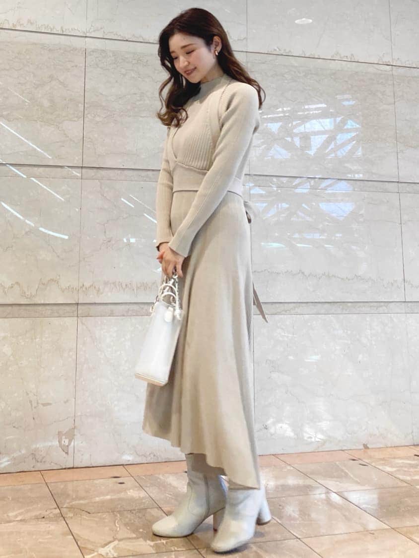 ベージュ系のワンピース、ホワイト系のハンドバッグを着用したレディースの冬コーディネートの3枚目の写真
