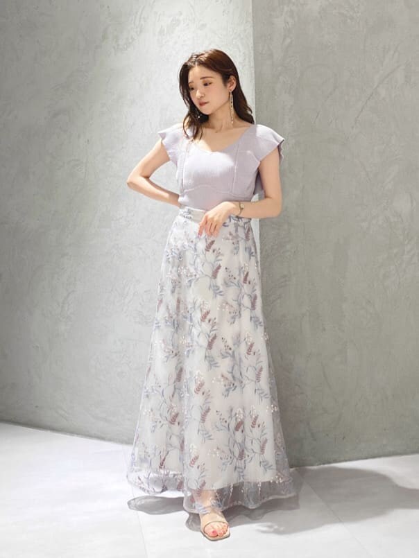 パープル系のニット/セーター、ブルー系のスカート、ベージュ系のサンダルを着用したレディースの春コーディネートの3枚目の写真