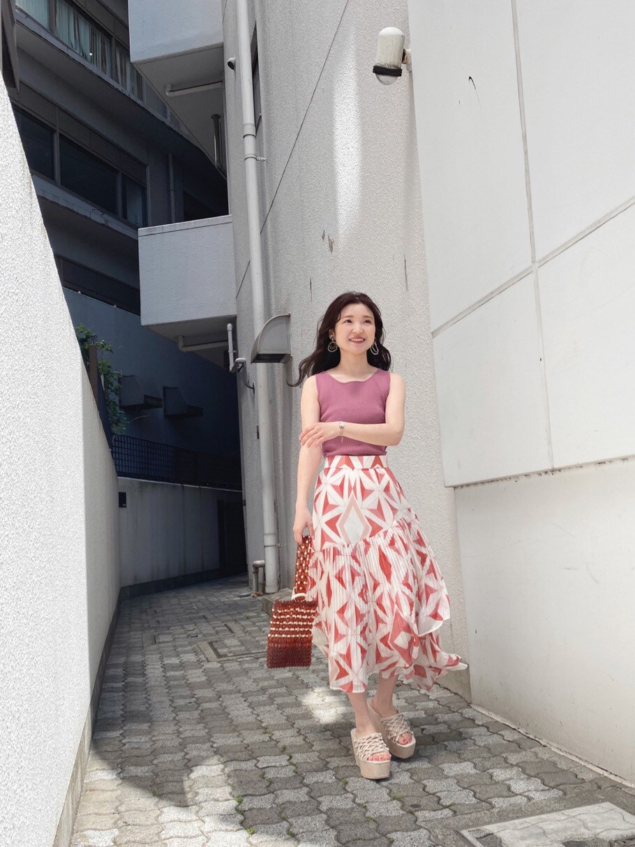 ホワイト系のサンダル、オレンジ系のスカート、ブラウン系のハンドバッグを着用したレディースの春コーディネートの8枚目の写真