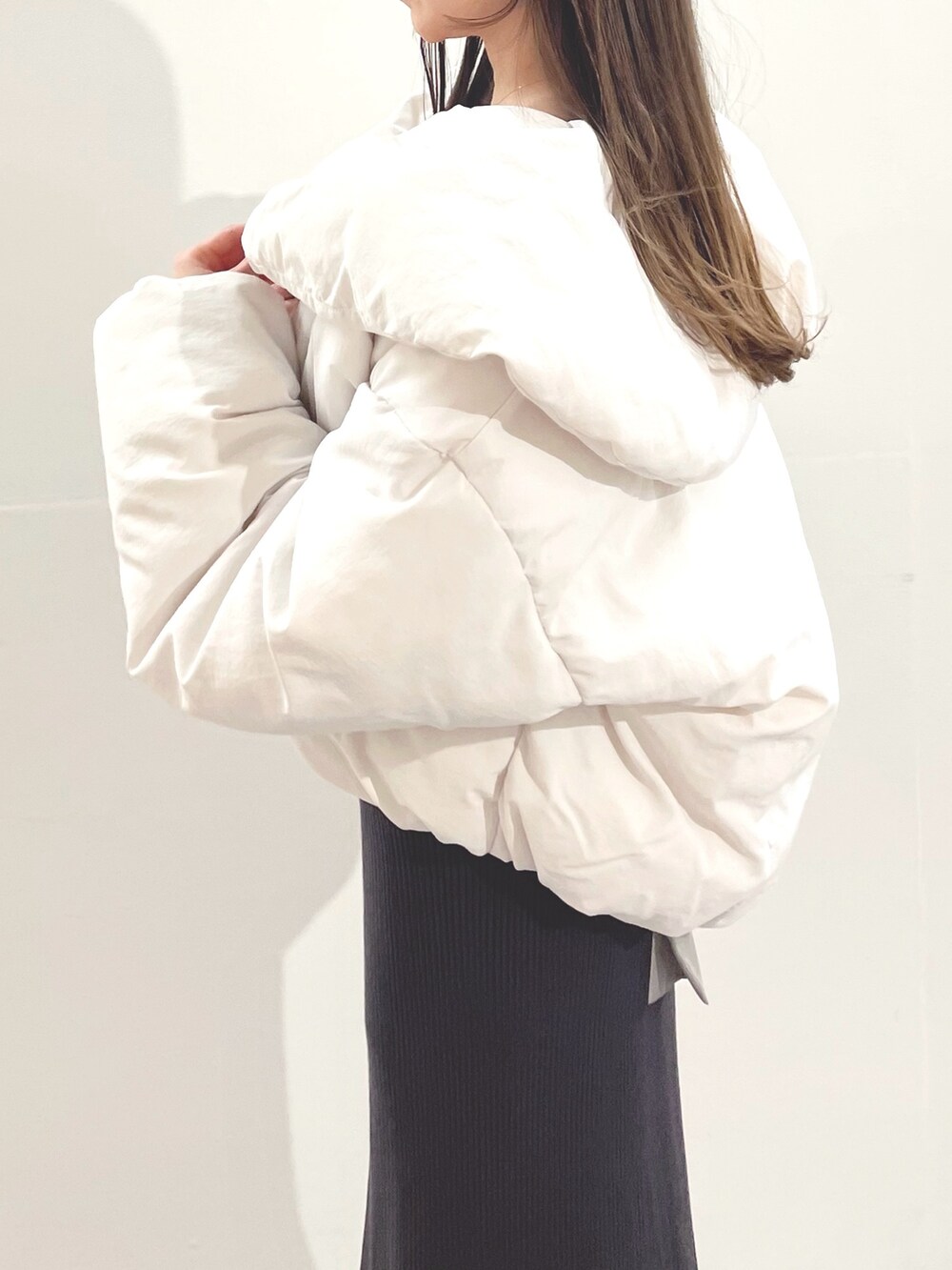 ホワイト系のブーツ、ホワイト系のダウンジャケット/コート、グレー系のワンピースを着用したレディースの冬コーディネートの4枚目の写真