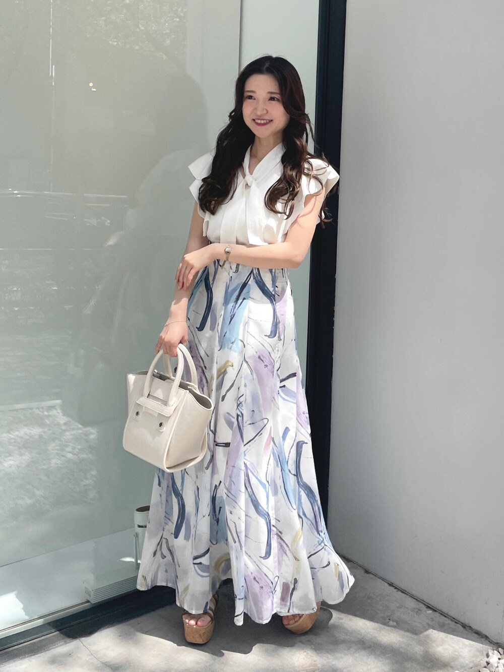 その他のサンダル、ホワイト系のニット/セーター、ホワイト系のハンドバッグを着用したレディースの夏コーディネートの2枚目の写真