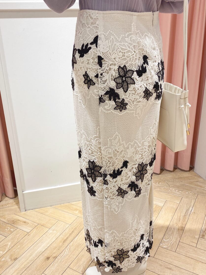 ホワイト系のその他シューズ、ホワイト系のスカート、パープル系のニット/セーターを着用したレディースの秋コーディネートの5枚目の写真