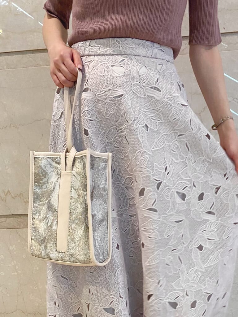 ホワイト系のその他シューズ、ベージュ系のハンドバッグ、ピンク系のニット/セーターを着用したレディースの夏コーディネートの6枚目の写真