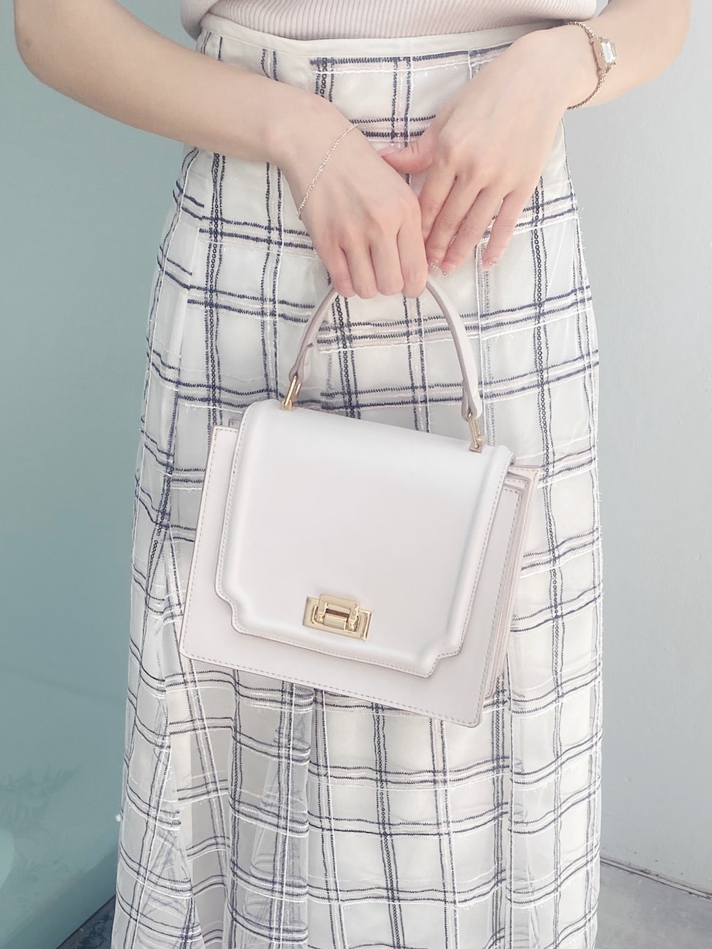 ホワイト系のサンダル、ホワイト系のハンドバッグ、ホワイト系のスカートを着用したレディースの夏コーディネートの6枚目の写真