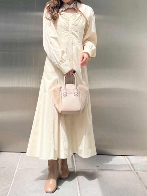 ベージュ系のブーツ、ホワイト系のハンドバッグ、ホワイト系のワンピースを着用したレディースの秋コーディネートの5枚目の写真