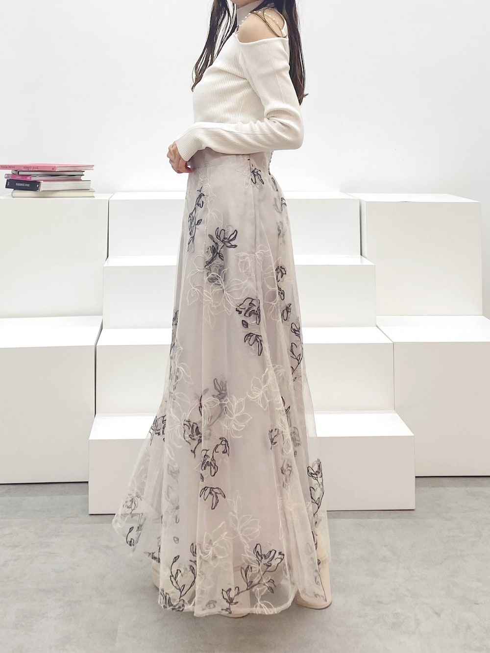 ホワイト系のブーツ、ホワイト系のニット/セーター、ベージュ系のスカートを着用したレディースの秋コーディネートの3枚目の写真