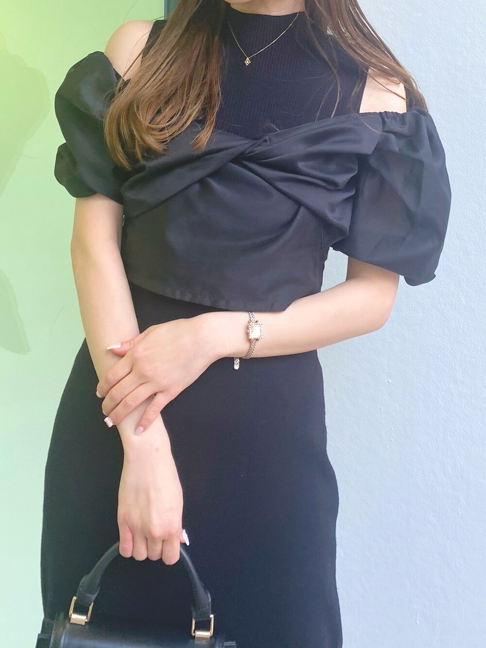 ホワイト系のサンダル、ブラック系のハンドバッグ、ブラック系のワンピースを着用したレディースの春コーディネートの4枚目の写真