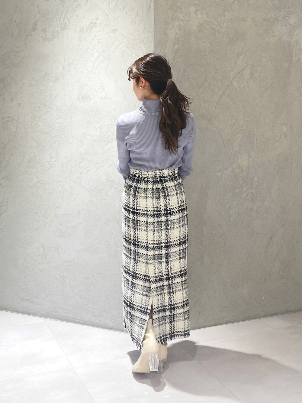 ホワイト系のブーツ、ホワイト系のスカート、ブルー系のニット/セーターを着用したレディースの冬コーディネートの4枚目の写真