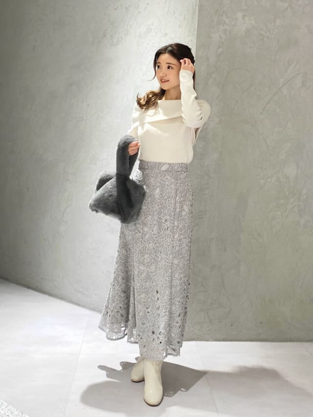 ホワイト系のニット/セーター、グレー系のスカートを着用したレディースの冬コーディネートの2枚目の写真