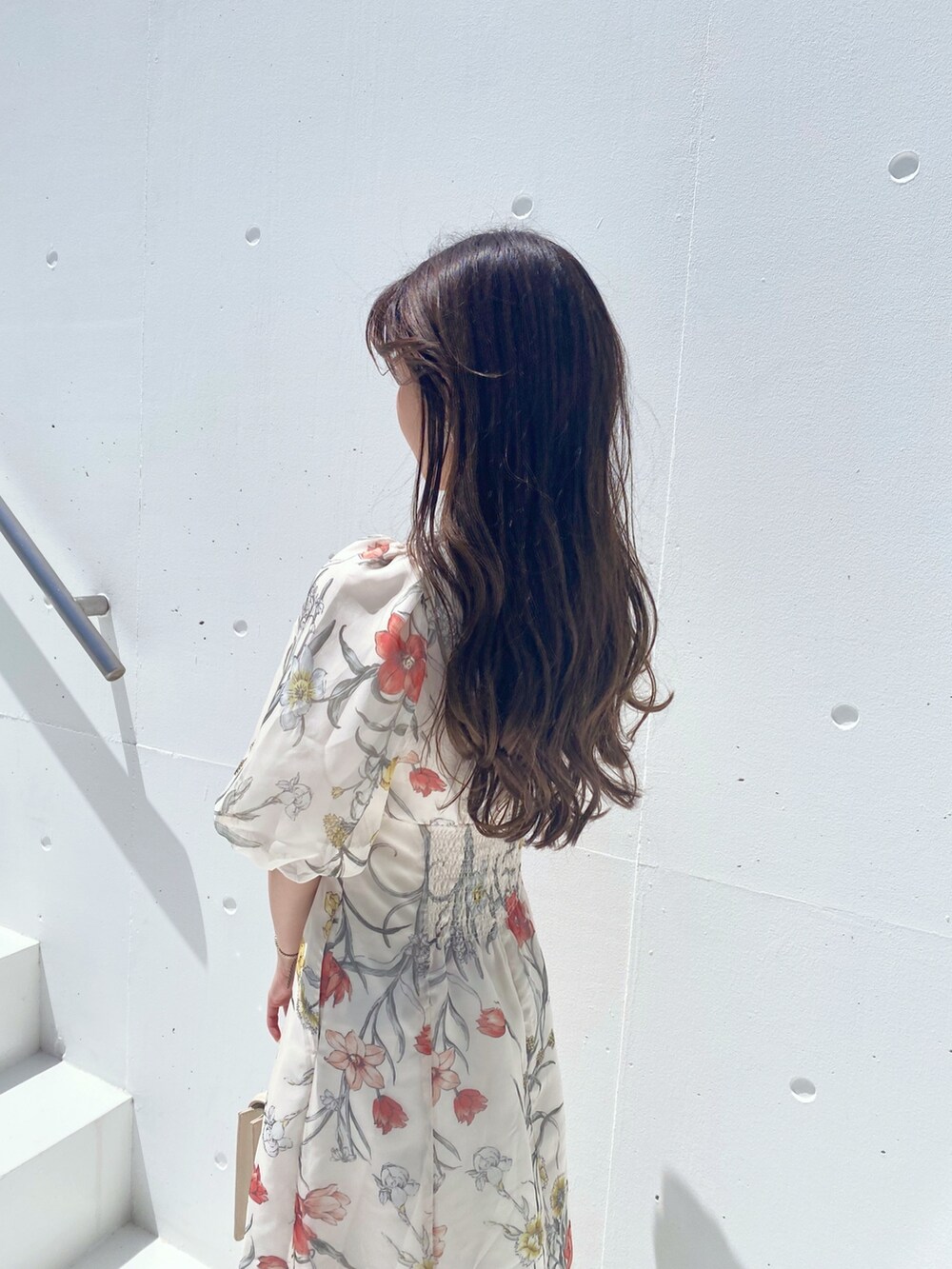 ホワイト系のハンドバッグ、ホワイト系のワンピース、ブラウン系のブーツを着用したレディースの夏コーディネートの3枚目の写真