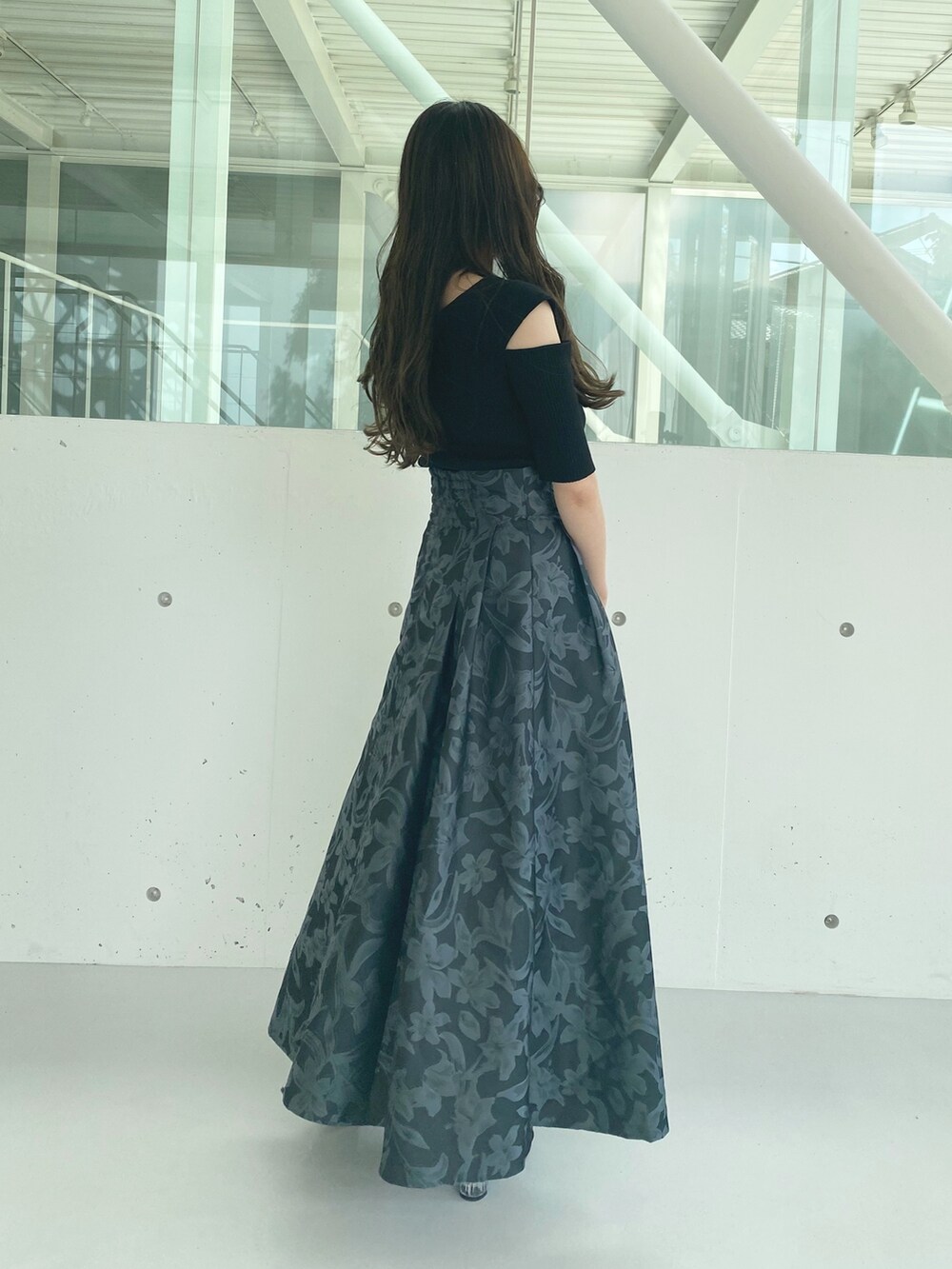 ブラック系のハンドバッグ、ブラック系のブーツ、ブラック系のニット/セーターを着用したレディースの秋コーディネートの6枚目の写真