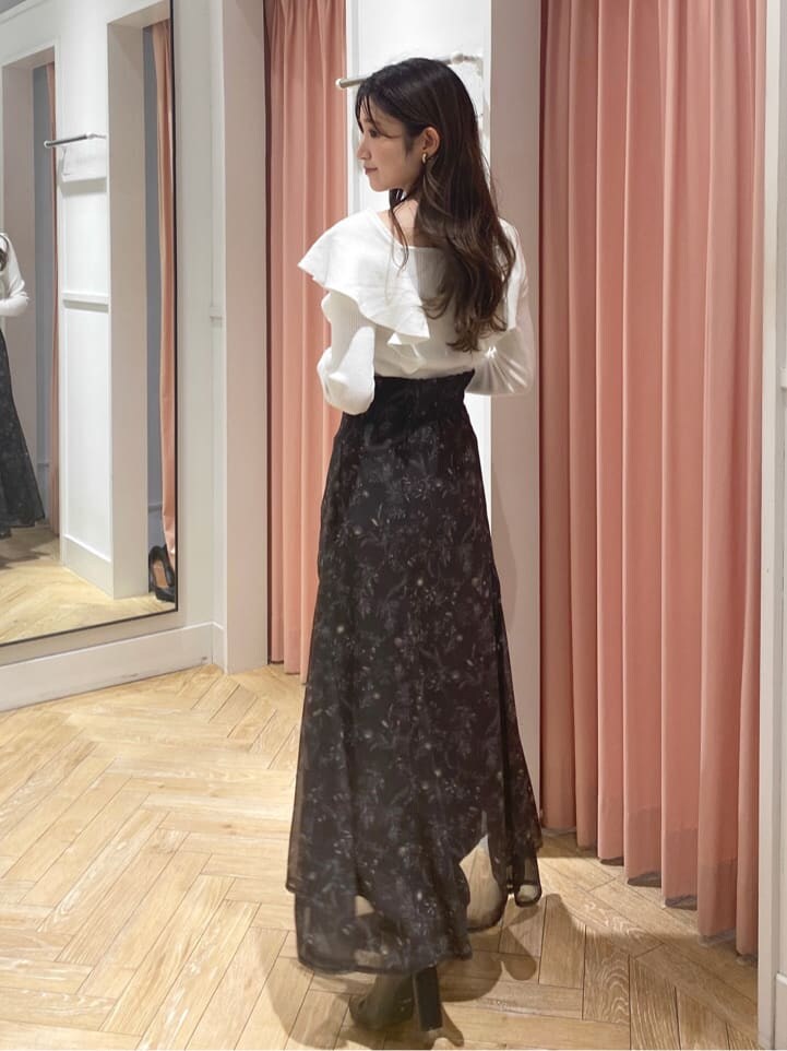 ベージュ系のムートンコート、ブラック系のブーツ、ホワイト系のニット/セーターを着用したレディースの秋コーディネートの9枚目の写真