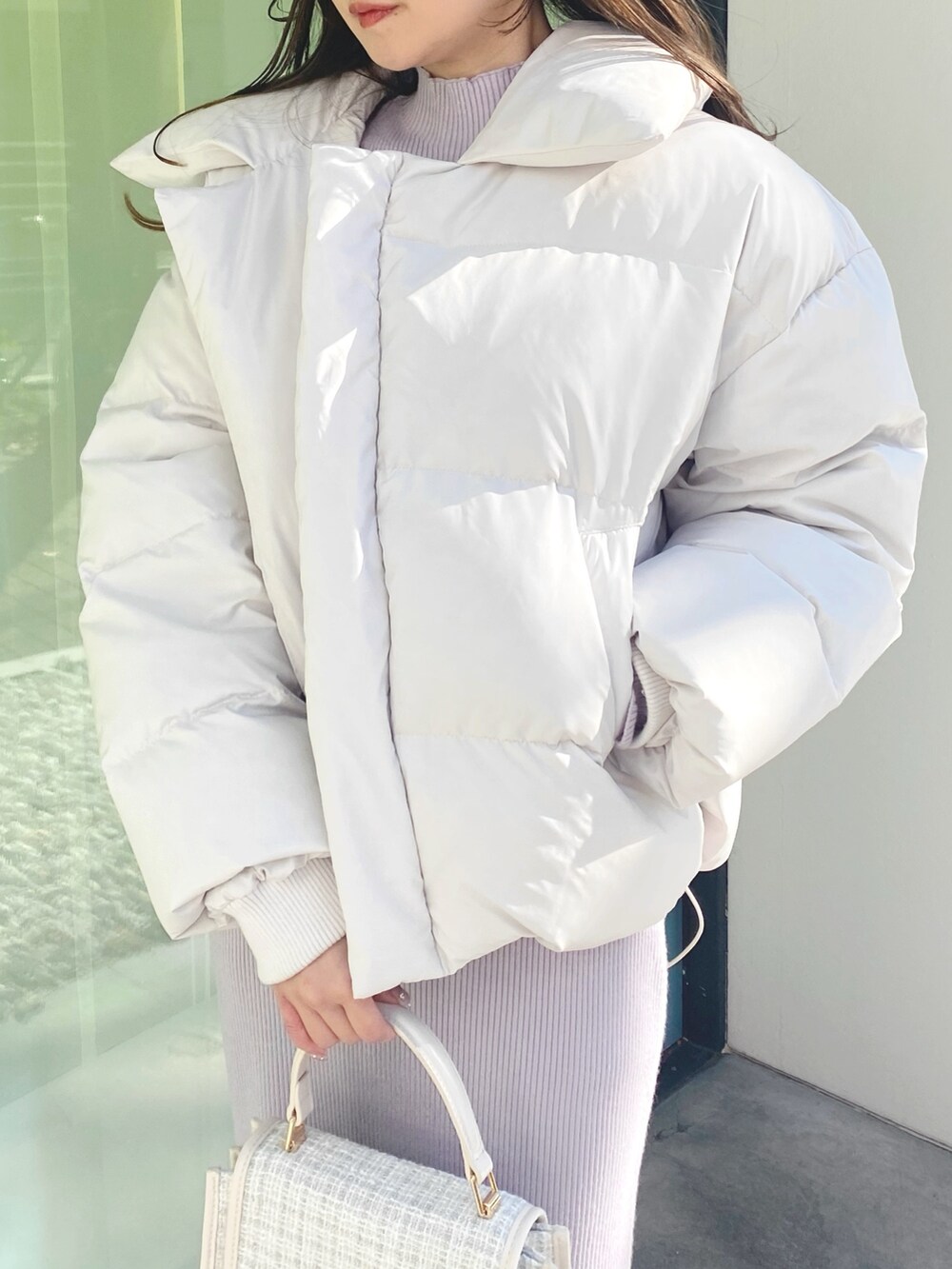 ピンク系のワンピース、ホワイト系のショルダーバッグ、ホワイト系のブーツを着用したレディースの冬コーディネートの5枚目の写真