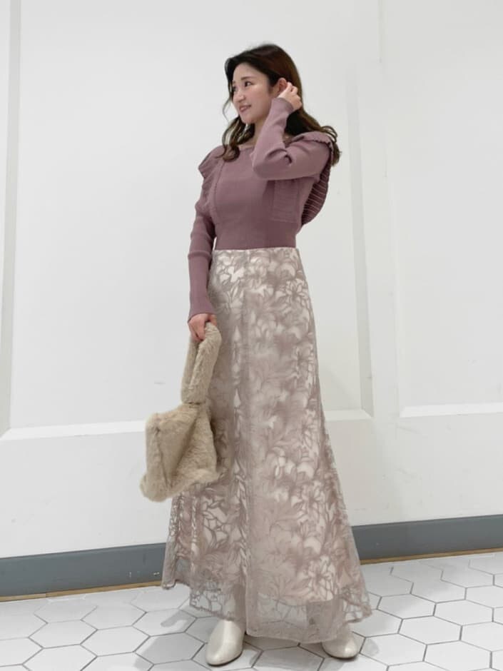 ブラウン系のニット/セーター、ベージュ系のハンドバッグ、ピンク系のスカートを着用したレディースの秋コーディネートの3枚目の写真