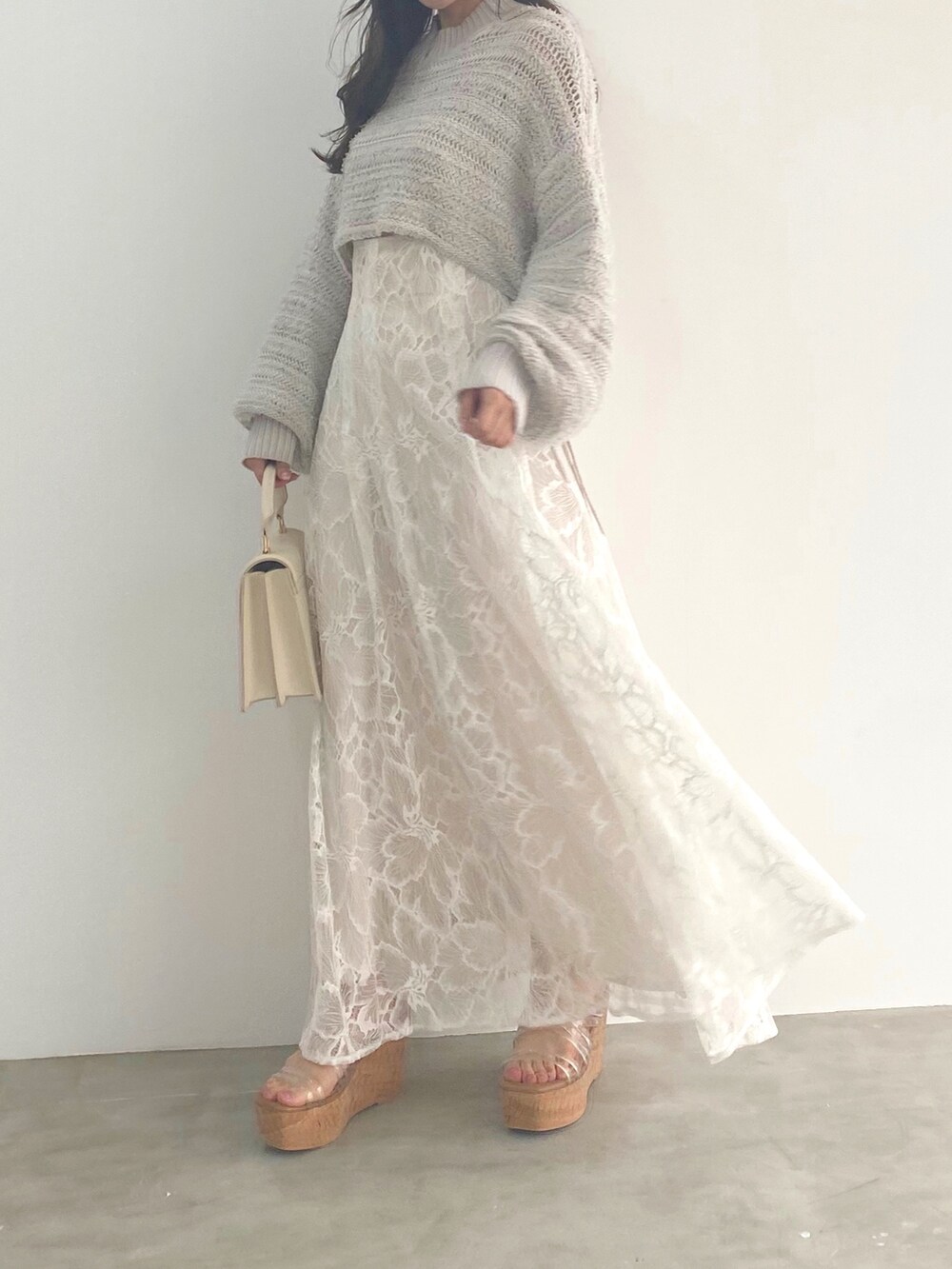 ホワイト系のサンダル、グレー系のニット/セーター、ホワイト系のハンドバッグを着用したレディースの冬コーディネートの3枚目の写真