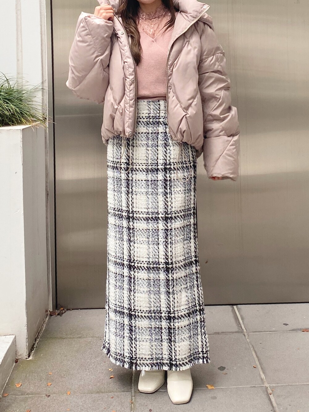 ホワイト系のブーツ、ホワイト系のスカート、ベージュ系のダウンジャケット/コートを着用したレディースの秋コーディネートの2枚目の写真