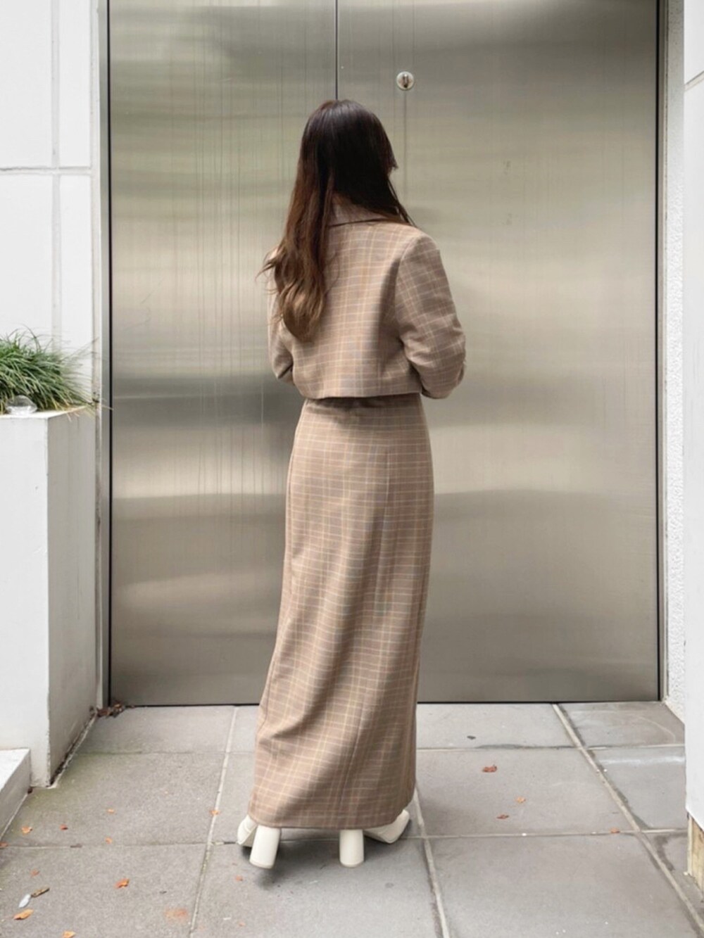 ベージュ系のテーラードジャケット、ベージュ系のスカート、ホワイト系のブーツを着用したレディースの秋コーディネートの6枚目の写真