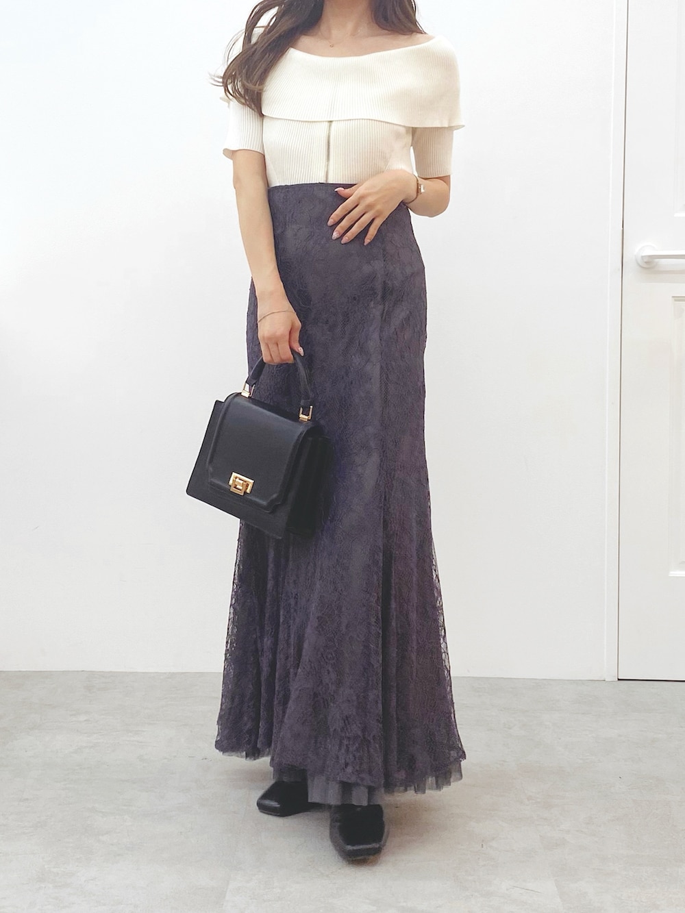 ホワイト系のニット/セーター、ブラック系のブーツ、グレー系のスカートを着用したレディースの秋コーディネートの3枚目の写真