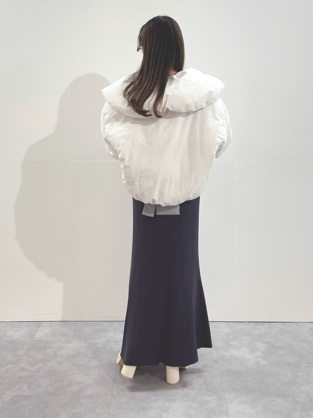 ホワイト系のブーツ、ホワイト系のダウンジャケット/コート、グレー系のワンピースを着用したレディースの冬コーディネートの5枚目の写真