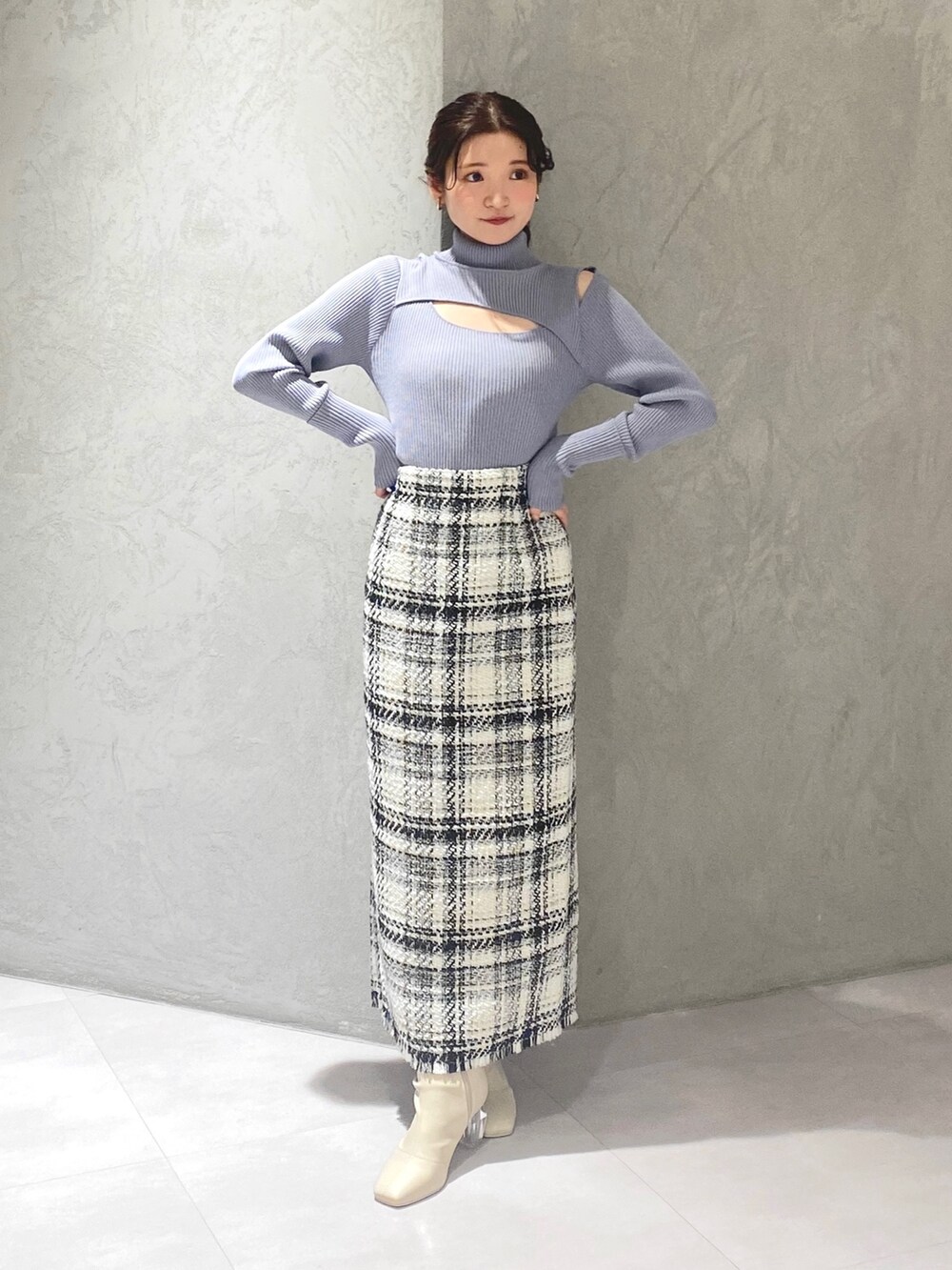 ホワイト系のブーツ、ホワイト系のスカート、ブルー系のニット/セーターを着用したレディースの冬コーディネートの2枚目の写真