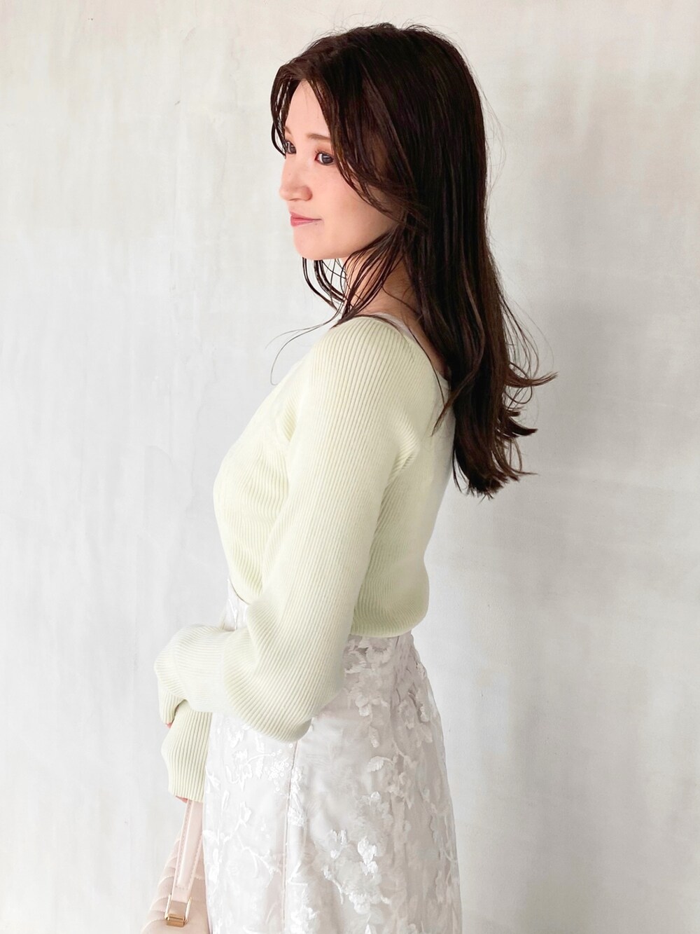 ホワイト系のスカート、ホワイト系のショルダーバッグ、グリーン系のニット/セーターを着用したレディースの秋コーディネートの4枚目の写真