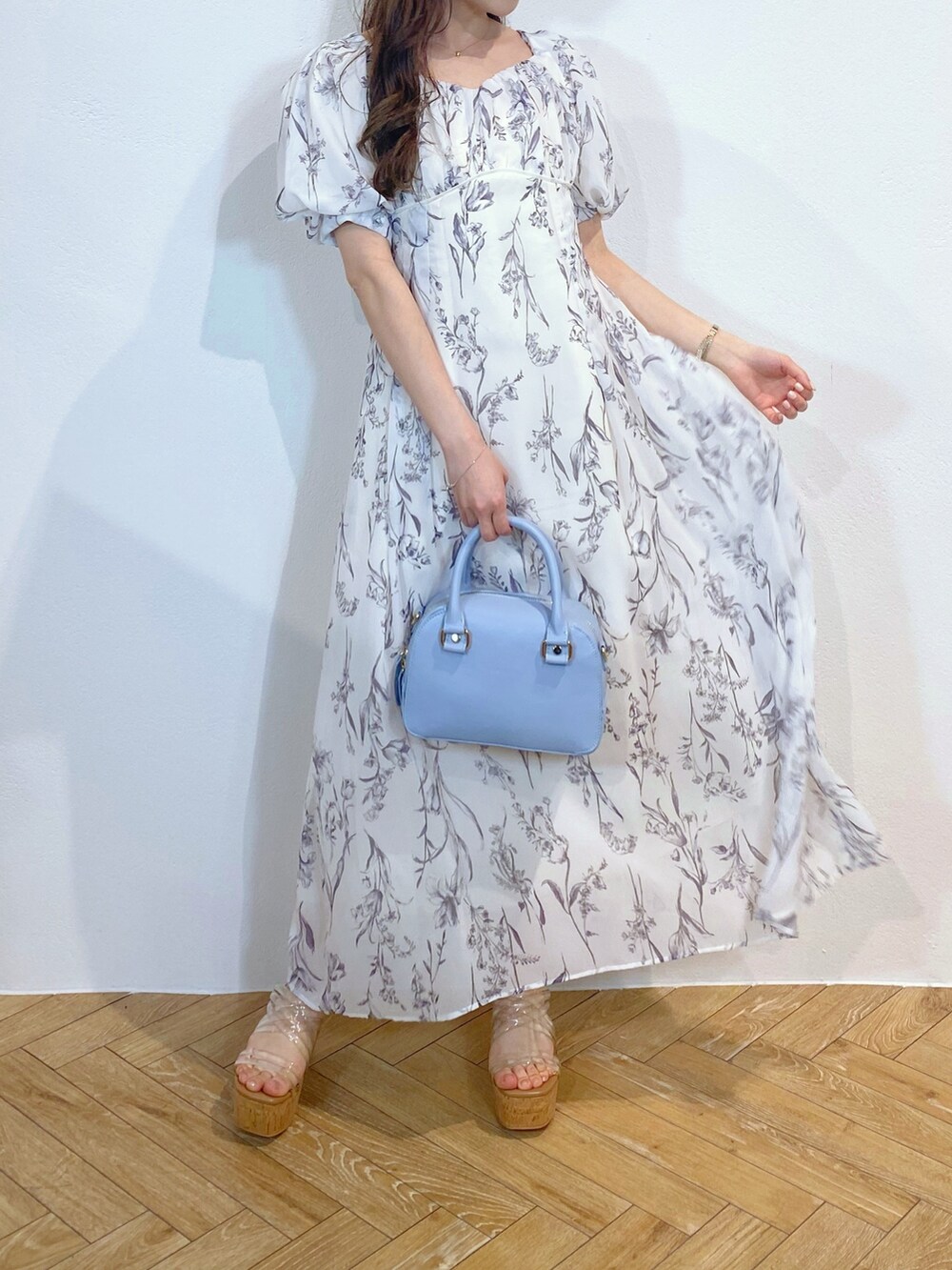 ブルー系のボストンバッグ、その他のサンダル、ホワイト系のワンピースを着用したレディースの夏コーディネートの2枚目の写真