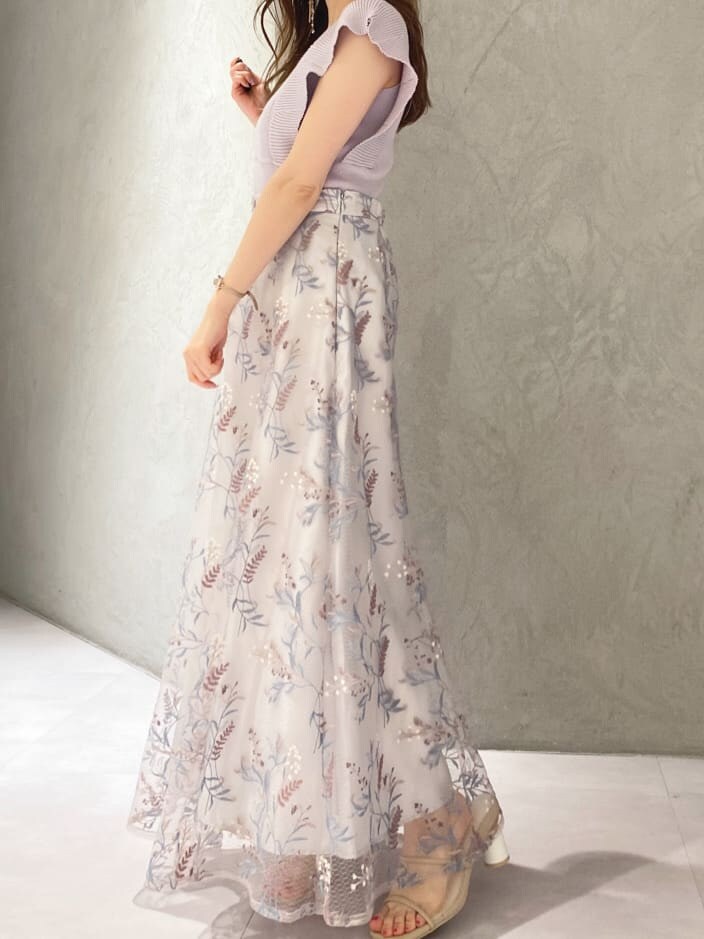 パープル系のニット/セーター、ブルー系のスカート、ベージュ系のサンダルを着用したレディースの春コーディネートの6枚目の写真