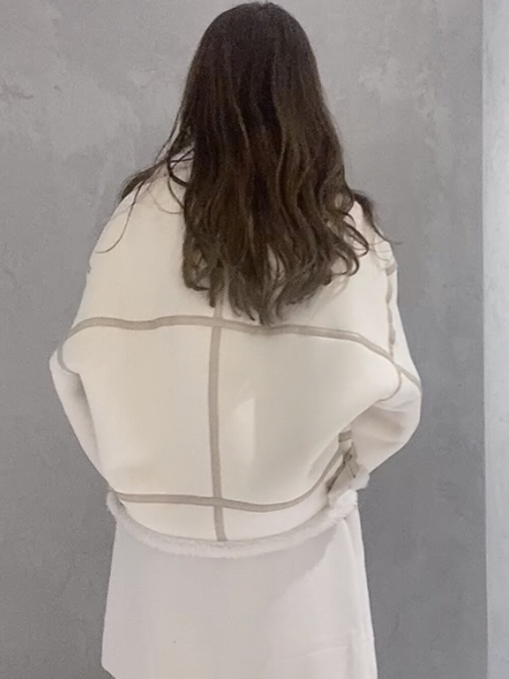 ベージュ系のハンドバッグ、ホワイト系のムートンコート、パープル系のニット/セーターを着用したレディースの冬コーディネートの5枚目の写真