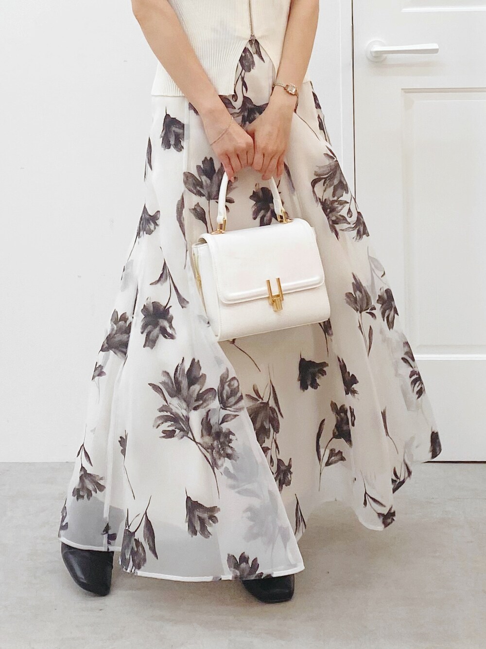 ホワイト系のニット/セーター、ホワイト系のスカート、ホワイト系のハンドバッグを着用したレディースの秋コーディネートの7枚目の写真