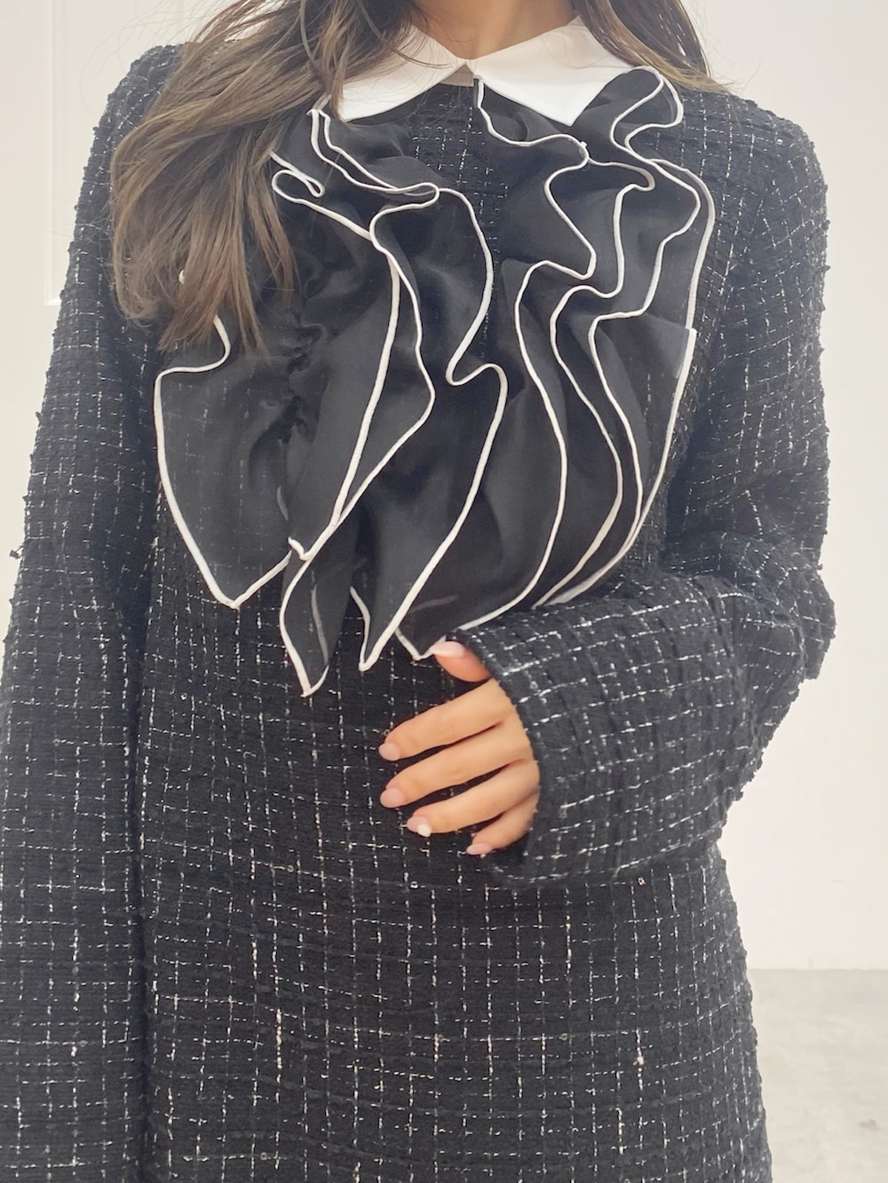 ブラック系のブーツ、ホワイト系のハンドバッグ、ブラック系のワンピースを着用したレディースの秋コーディネートの6枚目の写真