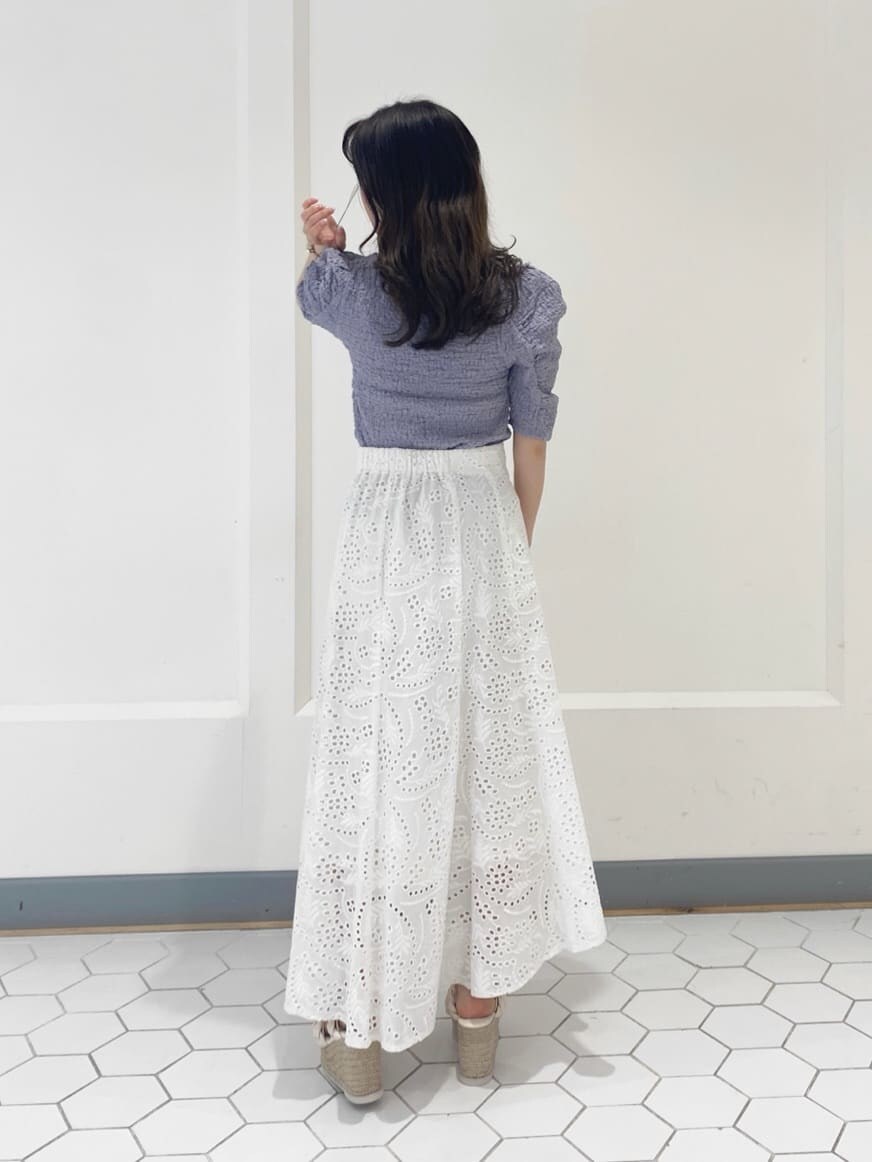 ホワイト系のスカート、パープル系のTシャツ/カットソー、ホワイト系のサンダルを着用したレディースの春コーディネートの8枚目の写真